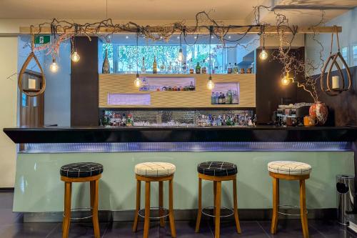 a bar with three stools in front of it at Hotel Marad in Torre del Greco