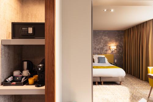 a hotel room with a bed and a mirror at Domaine du Gouverneur, Hôtel, Restaurant & Golf in Monthieux