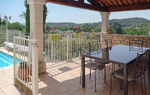 un patio avec une table et des chaises à côté d'une piscine dans l'établissement Nice Home In St Ambroix With Wifi, à Saint-Ambroix
