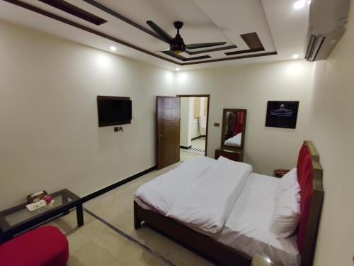 a bedroom with a bed and a ceiling fan at AL Fateh Hotel in Lahore