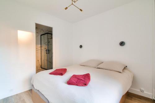 - un lit blanc avec 2 serviettes rouges dans l'établissement Charmant appartement Paris, à Paris