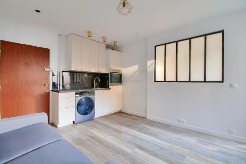Cette chambre comprend une cuisine équipée d'un lave-linge. dans l'établissement Charmant appartement Paris, à Paris
