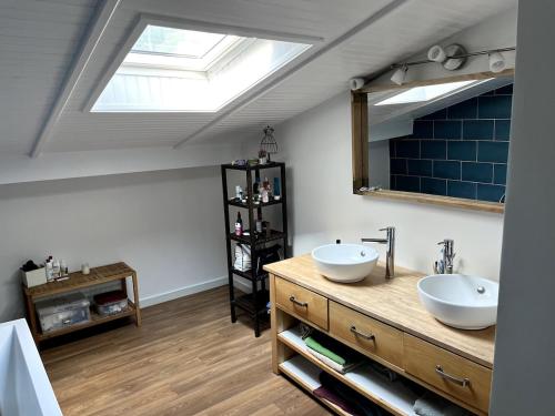 La salle de bains est pourvue de deux lavabos et d'une lucarne. dans l'établissement Villa au calme piscine chauffée dix couchages, à Seignosse