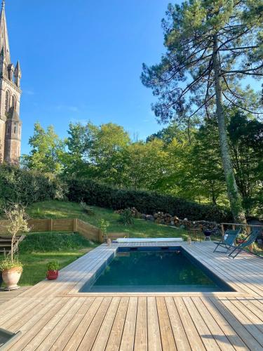 - une piscine sur une terrasse en bois à côté d'une cour dans l'établissement Villa au calme piscine chauffée dix couchages, à Seignosse