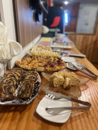 a wooden table with plates of food on it at Hotel Boutique Family Suites in Panguipulli