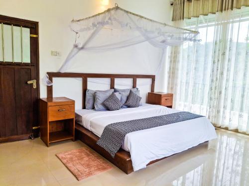 a bedroom with a bed with a canopy at Dew Drops Nature Villa in Parakaduwa