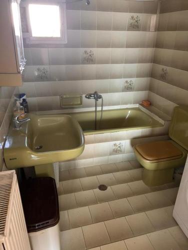 a bathroom with a tub and a sink and a toilet at Vasiliki's Village House in Xanthi