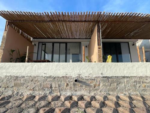 a house with a wooden roof over a brick wall at Seaside Mui Ne Hotel in Mui Ne