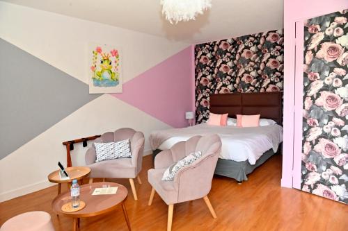 a bedroom with a bed and two chairs and a table at Logis Auberge De Launay in Limeray