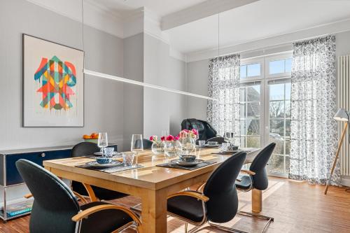 a dining room with a table and chairs at CLS Moderne Villa Bad Schwartau mit Garten für bis zu 6 Personen, 2 E-Ladesäulen, 3 Parkplätze, Loggia, Big GREEN EGG, Massagesessel, großes Haus zwischen Lübeck und Ostsee, ideale A1 Anbindung nach Hamburg, Lübeck, Timmendorfer Strand in Bad Schwartau