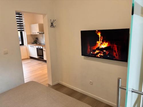 a living room with a fire on the wall at FourSuites Liège in Liège