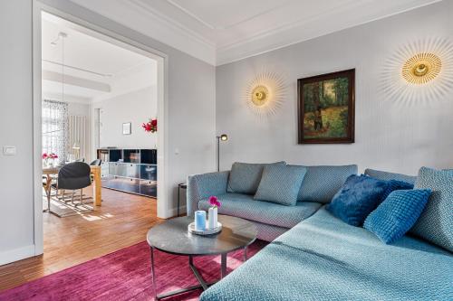a living room with a blue couch and a table at CLS Moderne Villa Bad Schwartau mit Garten für bis zu 6 Personen, 2 E-Ladesäulen, 3 Parkplätze, Loggia, Big GREEN EGG, Massagesessel, großes Haus zwischen Lübeck und Ostsee, ideale A1 Anbindung nach Hamburg, Lübeck, Timmendorfer Strand in Bad Schwartau