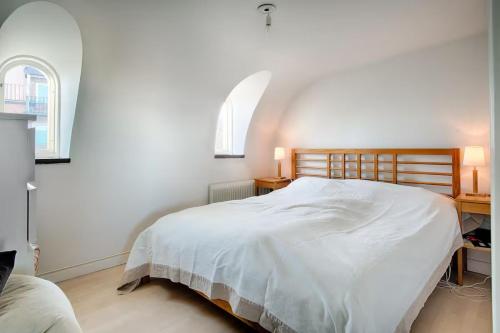 a bedroom with a large white bed with two windows at Spacious 5 bedroom house in Stockholm in Stockholm