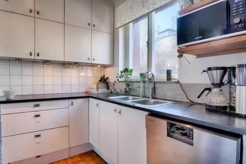 a kitchen with white cabinets and a sink at Spacious 5 bedroom house in Stockholm in Stockholm