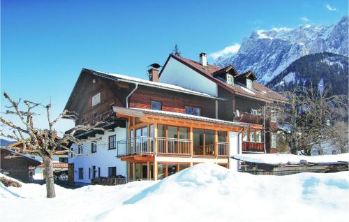 a house in the snow with mountains in the background at Helle Ferienwohnung In Ehrwald in Ehrwald