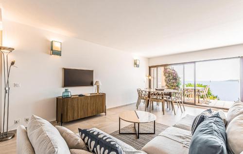 a living room with a couch and a tv and a table at 3 Bedroom Amazing Home In Sainte Maxime in La Nartelle