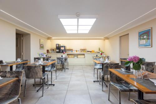 a restaurant with tables and chairs and a kitchen at Hôtel Amirauté in Toulon