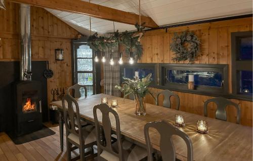 a dining room with a wooden table and a fireplace at 3 Bedroom Amazing Home In Tysse in Tysse