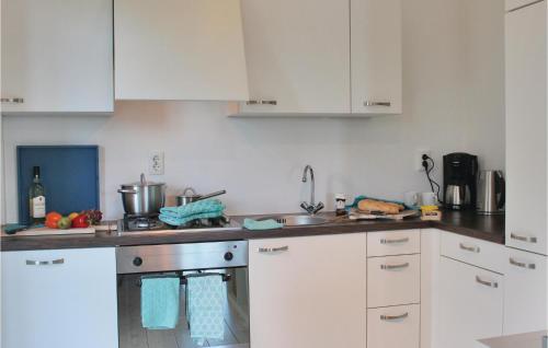 a kitchen with white cabinets and a sink at Holiday Home Breukelen Iv in Breukelen