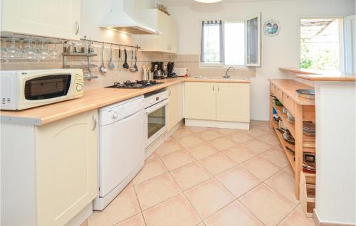 une cuisine avec des armoires blanches et un micro-ondes dans l'établissement Stunning Home In Bordezac With Wifi, à Bordezac