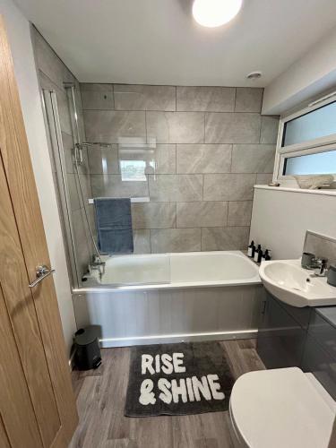 a bathroom with a tub and a toilet and a sink at Charming 2 bedroom flat in Basingstoke centre in Basingstoke