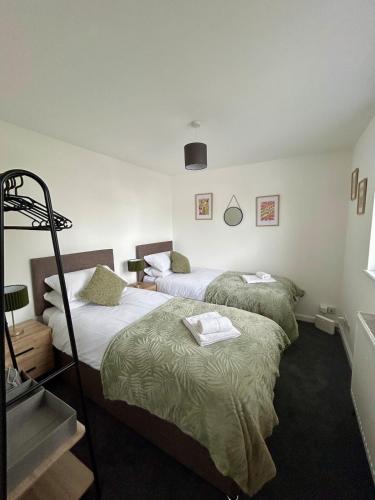 two twin beds in a room with a staircase at Charming 2 bedroom flat in Basingstoke centre in Basingstoke