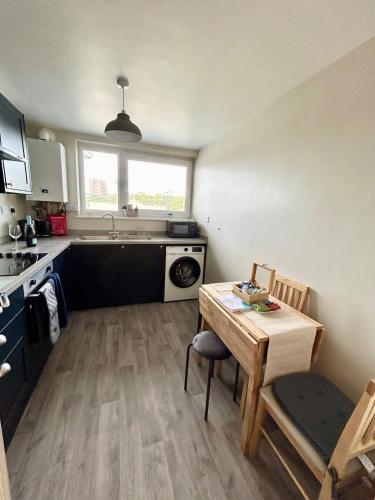 a small kitchen with a table and a sink at Charming 2 bedroom flat in Basingstoke centre in Basingstoke