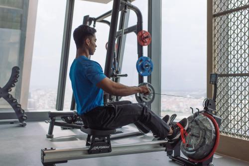 a man sitting on a gym machine with a disc at Rosewood Phnom Penh in Phnom Penh