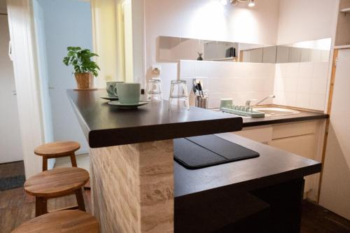 une cuisine avec un comptoir avec des tabourets et un évier dans l'établissement Plein cœur Historique de Caen - Quartier animé - au pied des boutiques, bars et restaurants, à Caen