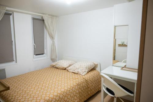 une petite chambre avec un lit et un bureau dans l'établissement Plein cœur Historique de Caen - Quartier animé - au pied des boutiques, bars et restaurants, à Caen