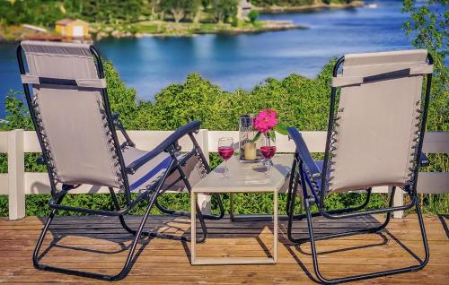 two chairs and a table with two glasses of wine at Cozy Apartment In Sveio With Kitchen in Sveio