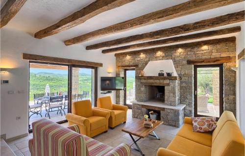 a living room with yellow furniture and a stone fireplace at Villa Banic in Motovun