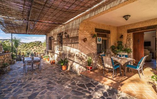 エル・ガストルにある2 Bedroom Beautiful Home In El Gastorの石壁のパティオ(テーブル、椅子付)