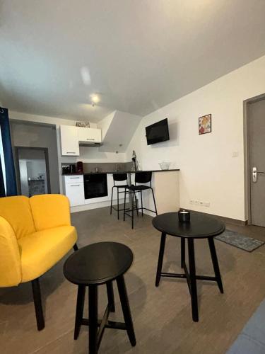 - un salon avec un canapé jaune et 2 tables dans l'établissement Comfortable A C, nice decor, au Luc