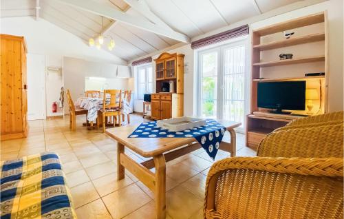 a living room with a table and a tv at 2 Bedroom Awesome Home In Bredene in Bredene