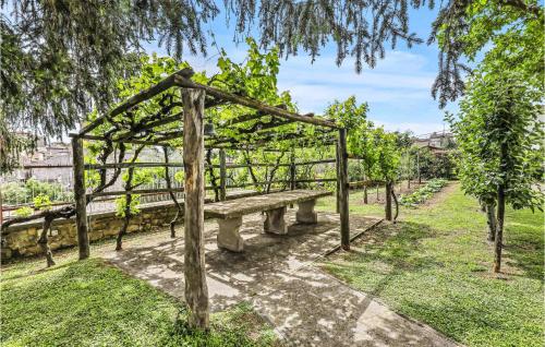 a stone bench in a park with a wooden structure at Awesome Home In Vitorchiano With Wifi in Vitorchiano