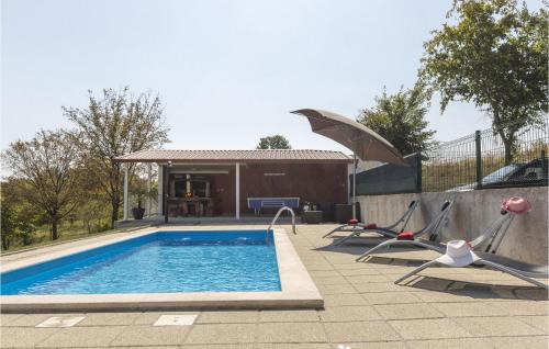 a pool with chairs and an umbrella next to a house at Villa Ana Istra in Novaki Motovunski