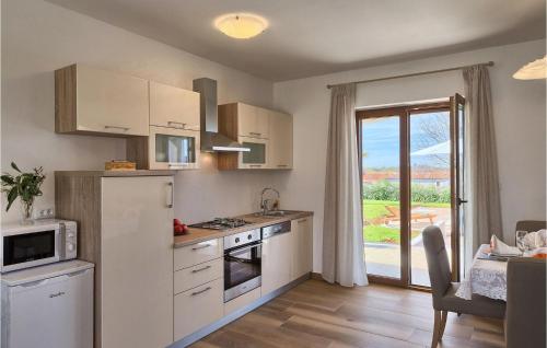 a kitchen with white appliances and a table and a window at Villa Montreo in Muntrilj