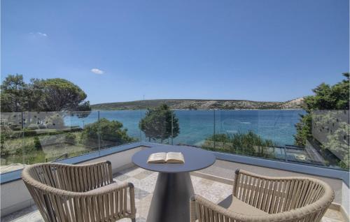 a balcony with a table and chairs and a view of the water at Villa Lunjsko in Stara Novalja