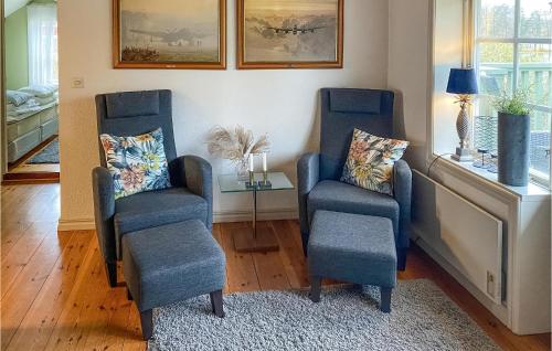 two blue chairs and a table in a room at Nice Home In Hjältevad With Sauna in Hjältevad