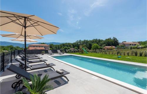 a swimming pool with lounge chairs and an umbrella at Villa Ani Krsan in Potpićan