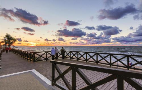 a group of people walking on a pier at sunset at 3 Bedroom Beautiful Home In Mscicie in Podamirowo