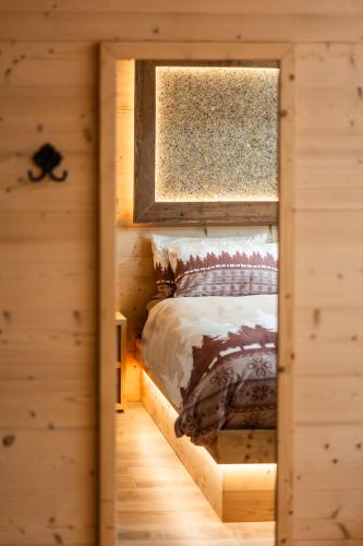 a bedroom with a bed in a log cabin at le Gemme - Dolomites escape in Dosoledo
