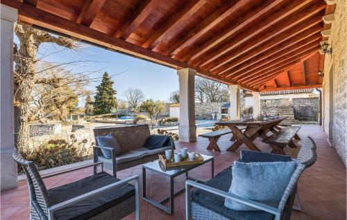 un patio avec une table et des chaises ainsi qu'un toit en bois dans l'établissement Villa Marija Korenici, à Rovinj