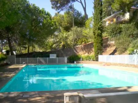 une piscine avec de l'eau bleue dans une cour dans l'établissement Studio avec piscine à 5 min de la plage, à La Seyne-sur-Mer