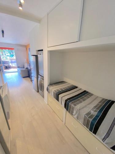 Cette petite chambre comprend deux lits et un réfrigérateur. dans l'établissement Studio avec piscine à 5 min de la plage, à La Seyne-sur-Mer