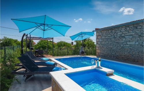 a pool with two umbrellas and two chairs and a swimming pool at Villa Imela in Pula