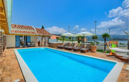 een zwembad met stoelen en een huis bij Villa Mek in Zadar