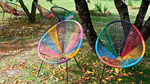 a group of colorful chairs sitting in the grass at Logis Auberge De Launay in Limeray