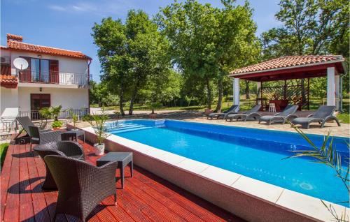 a pool with chairs and a gazebo next to a house at Cozy Home In Kapelica With Wifi in Raša